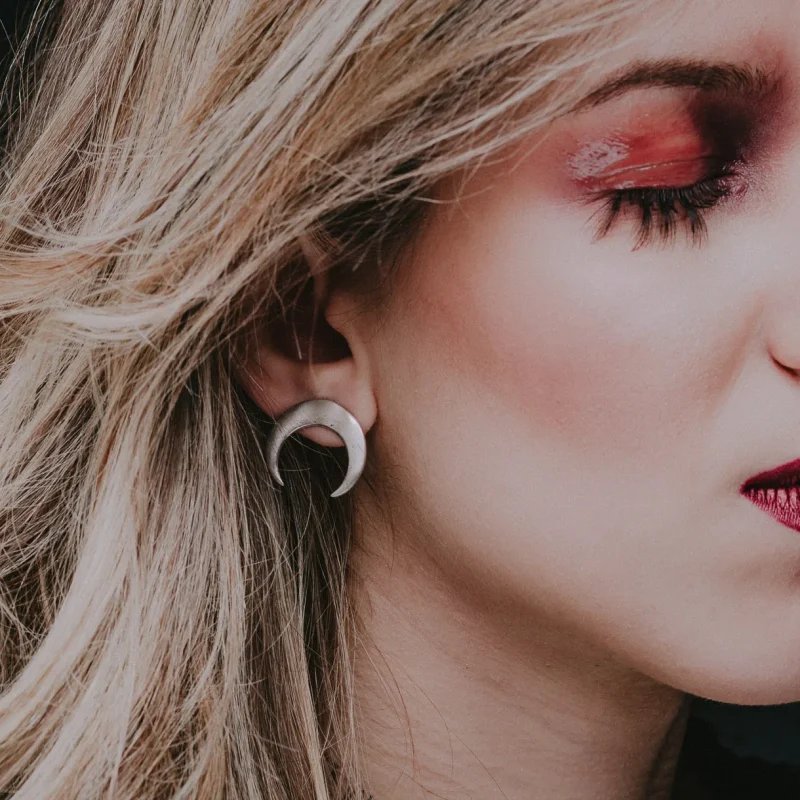 An image of a woman wearing a pair Moon Sterling Silver Earrings, handcrafted by Marren Jewelry in Greece.