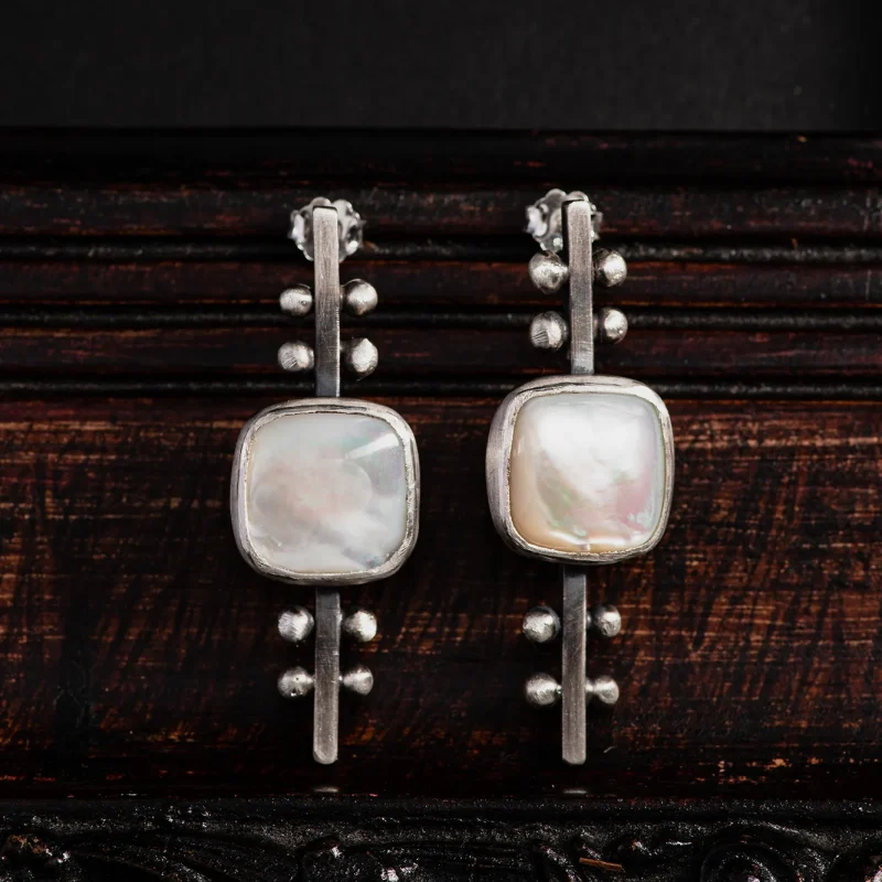 An image showing a Mother of Pearl Sterling Silver Stud Earrings, handcrafted by Marren Jewelry in her studio in Greece.