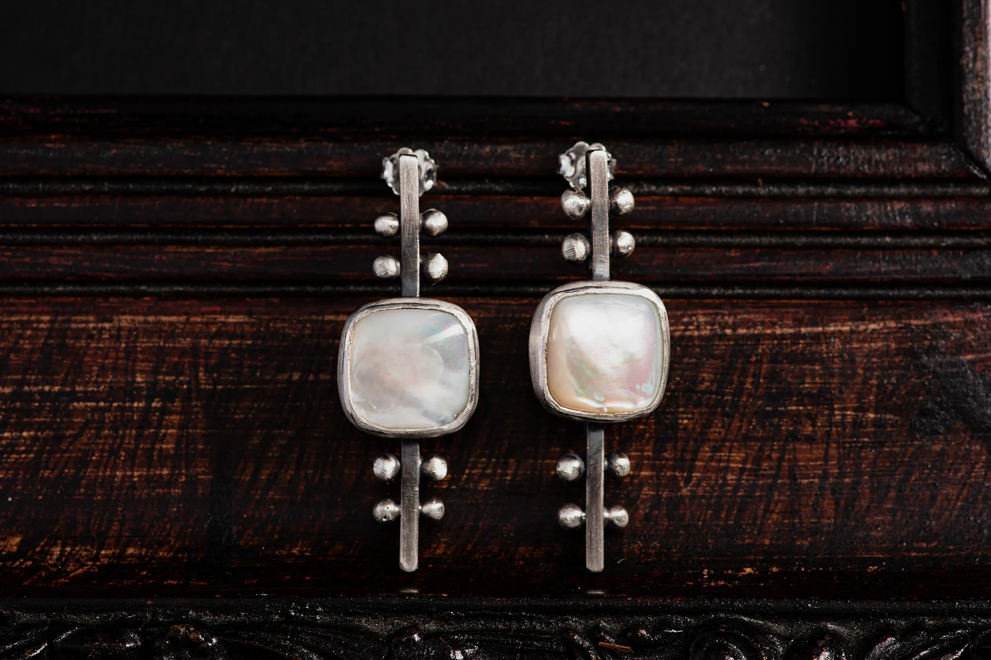 An image showing a Mother of Pearl Sterling Silver Stud Earrings, handcrafted by Marren Jewelry in her studio in Greece.