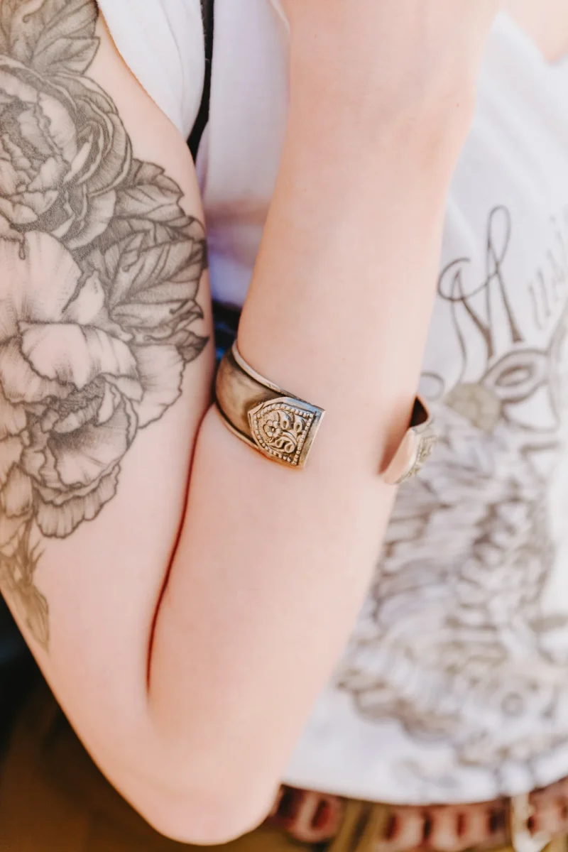 An image showing a chunky sterling silver cuff wide bracelet with ornament