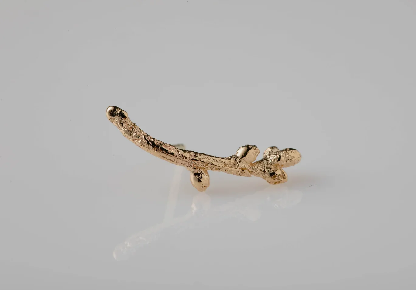 An image showing a 14K Gold Twig Ear Climber. It is handcrafted at Marren Jewelry studio in Greece.
