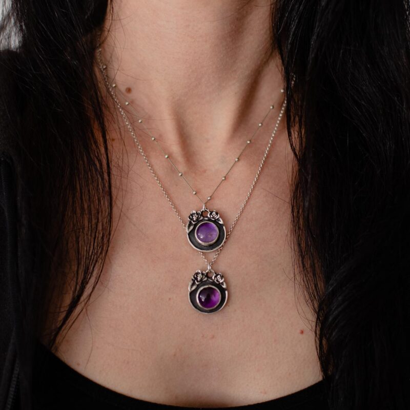 an image showing a model wearing two amethysts steling silver pendants