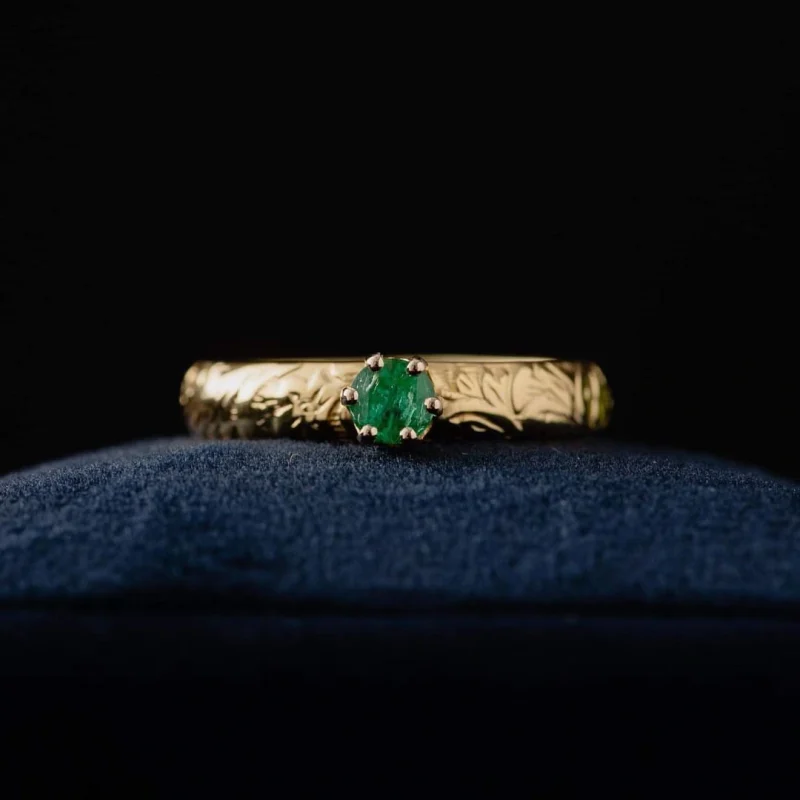An image showing an emerald 14K gold floral band ring