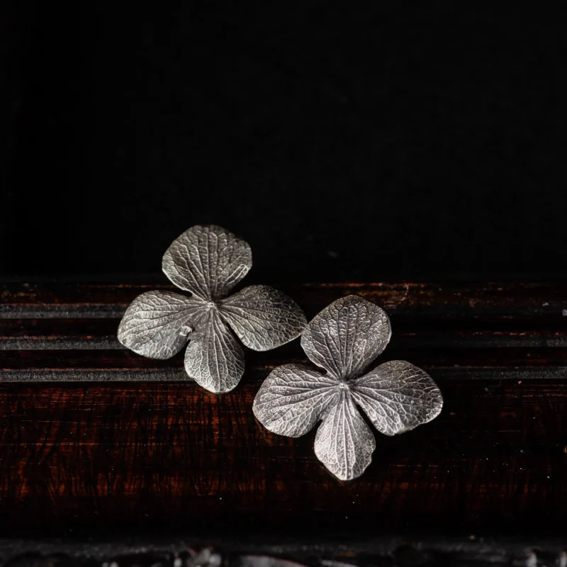 A picture showing a pair of detailed hydrangea earrings in sterling silver