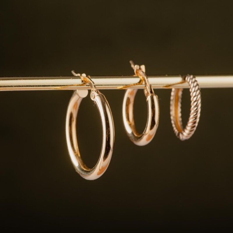 Three 14K gold hoop earrings hanging