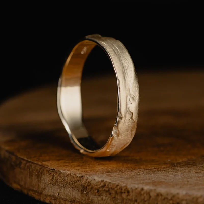 An image showing a textured 14K yellow gold wedding band ring for men