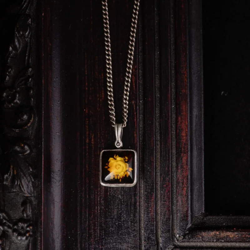 An image showing a sterling silver rose carved amber pendant