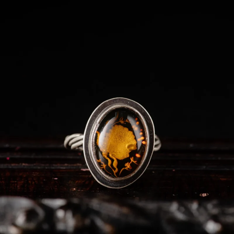 An image showing a carved shell amber sterling silver ring