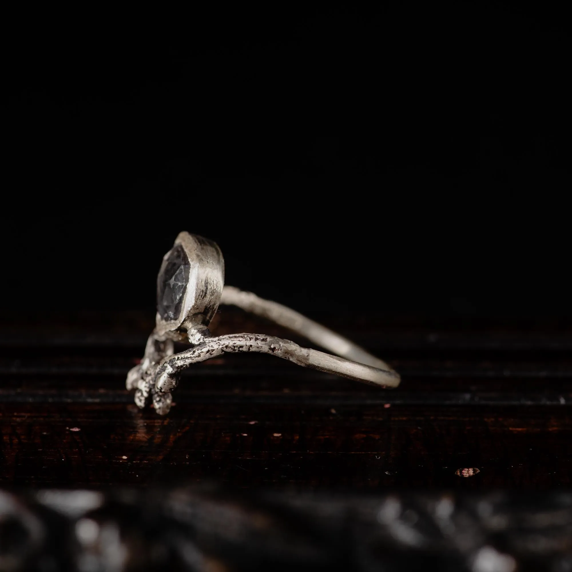 An image showing a subtle grey tourmaline sterling silver twig ring from the side