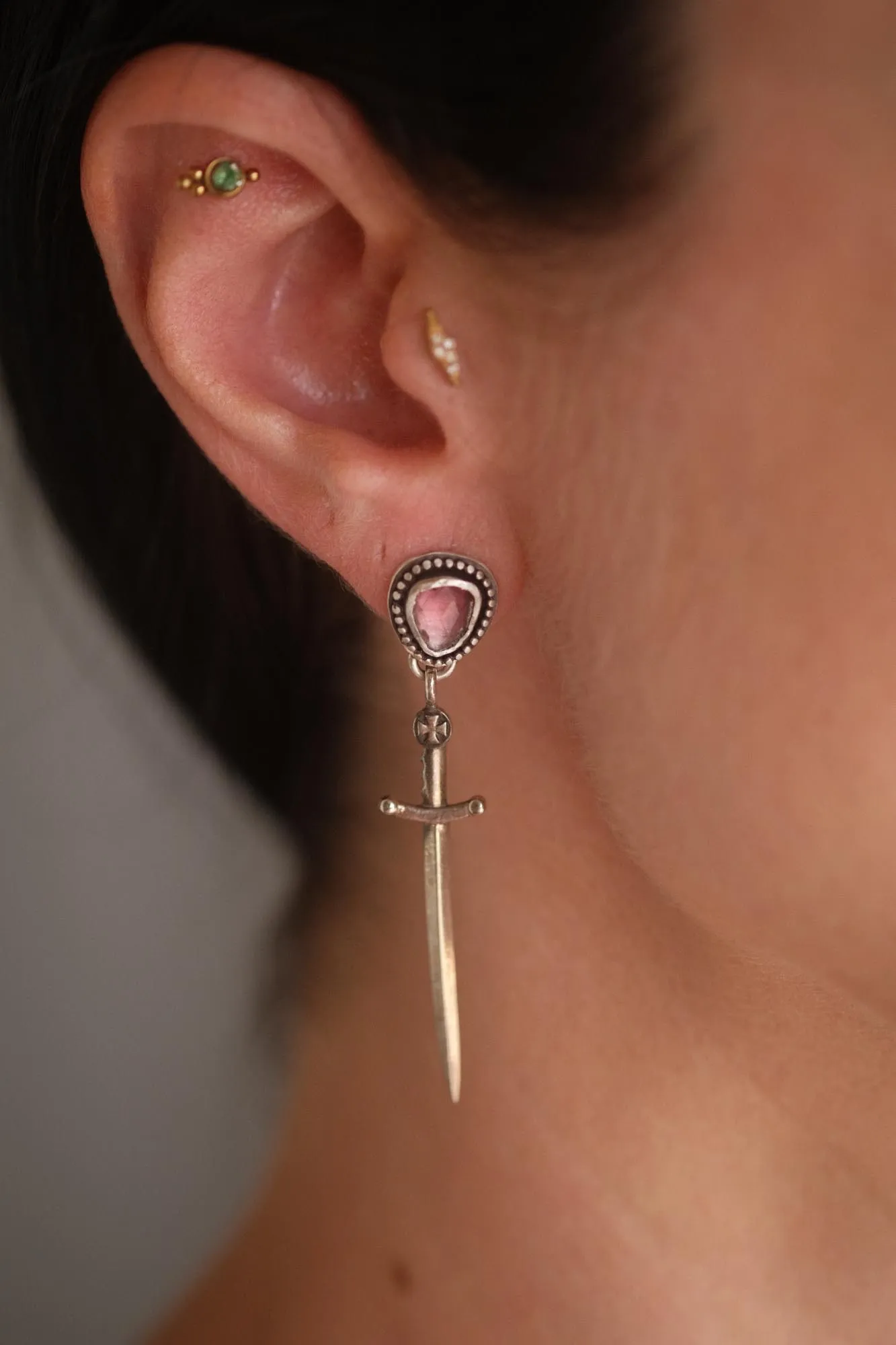 An image a dagger sterling silver earring featuring pink tourmaline on an ear