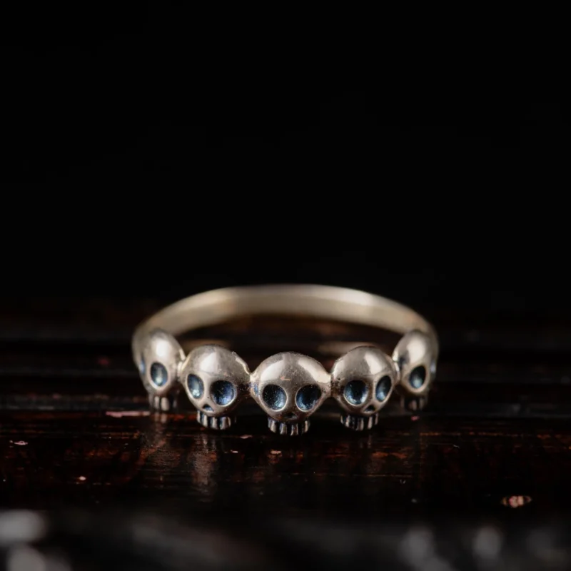 An image showing a sterling silver skull ring featuring 5 mini skulls on top