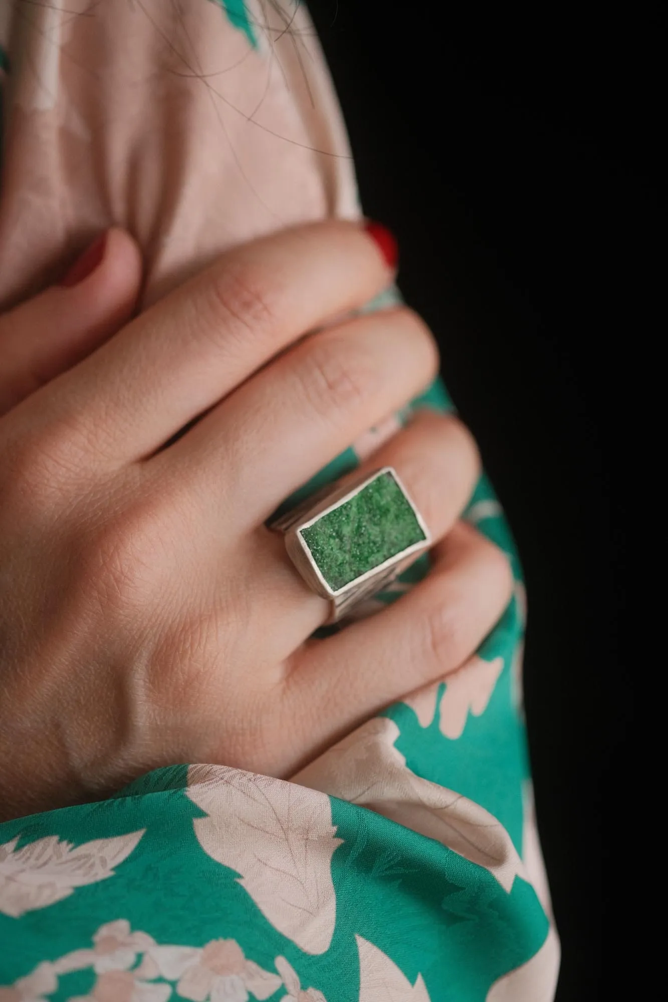 An image showing a juicy green uvarovite worn on a finger