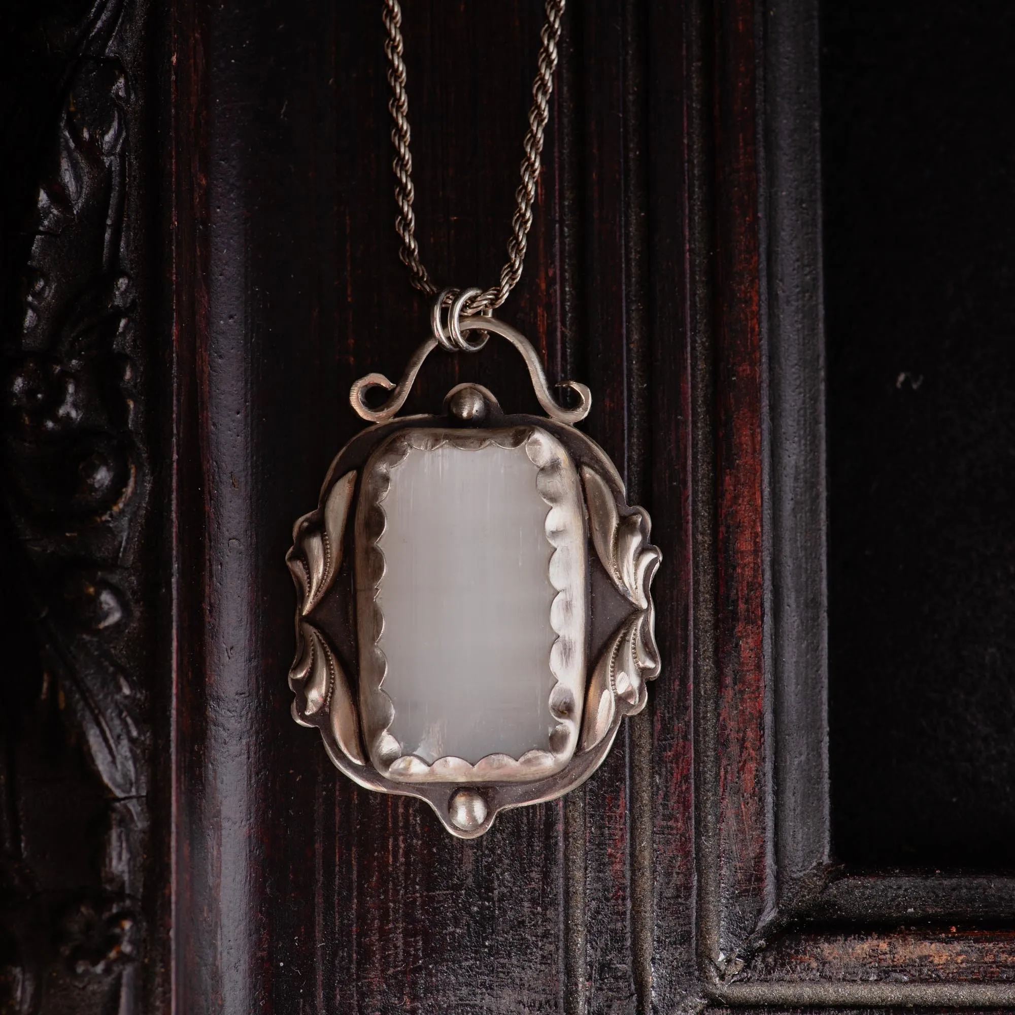 An image showing a white selenite sterling silver pendant that is victorian inspired