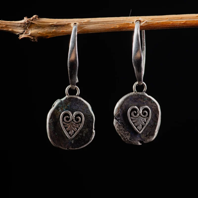 An image showing a sterling silver pair of earrings with heart acanthus motifs
