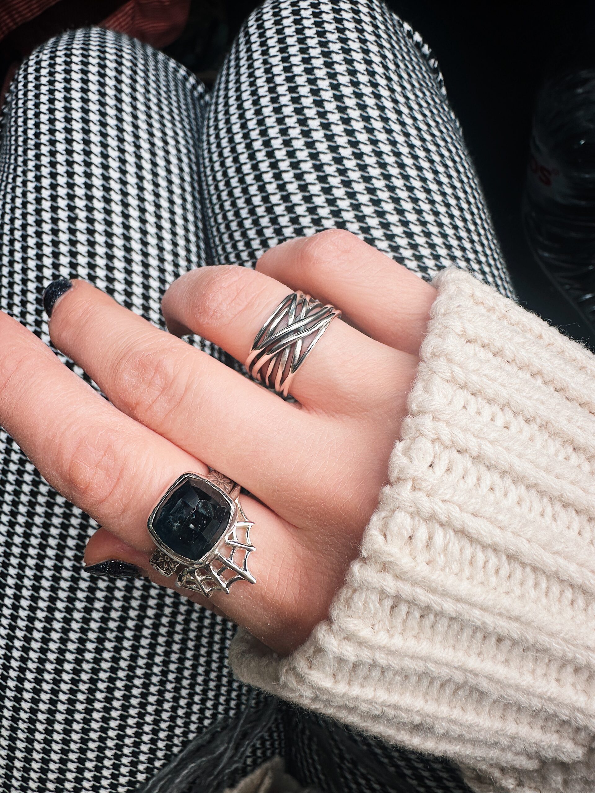 An image showing three sterling silver rings worn on a hand