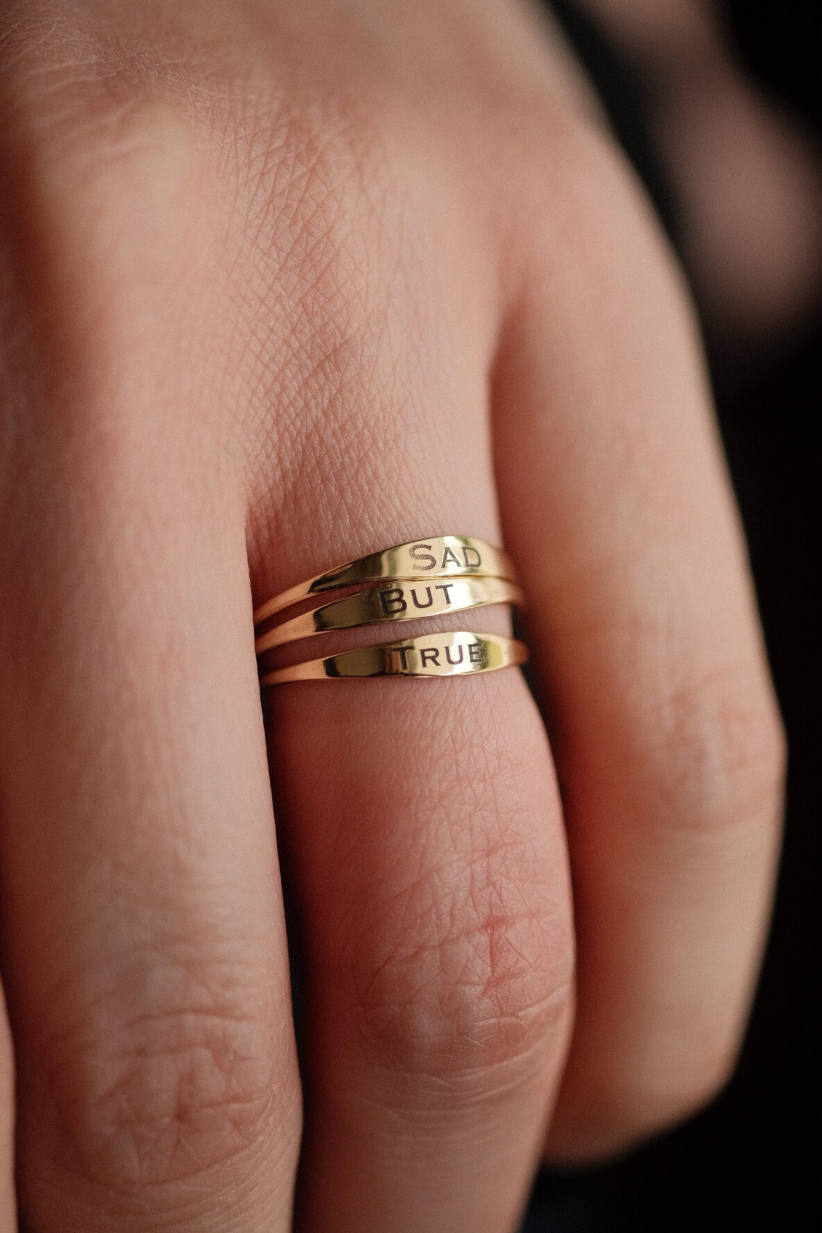 an image showing three solid gold signet rings with the engraving sad but true
