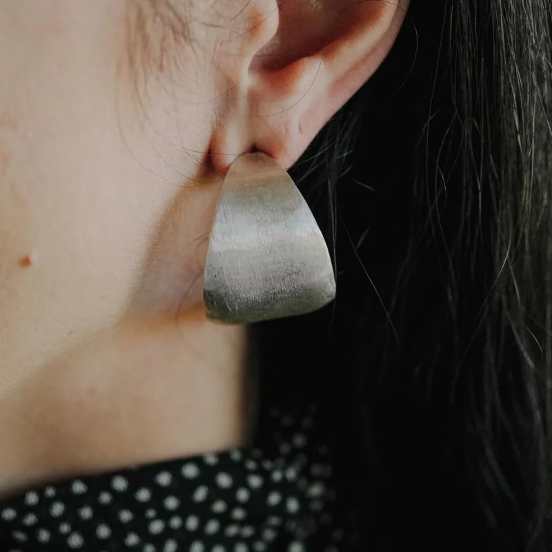 An image showing chunky sterling silver hoops on an ear